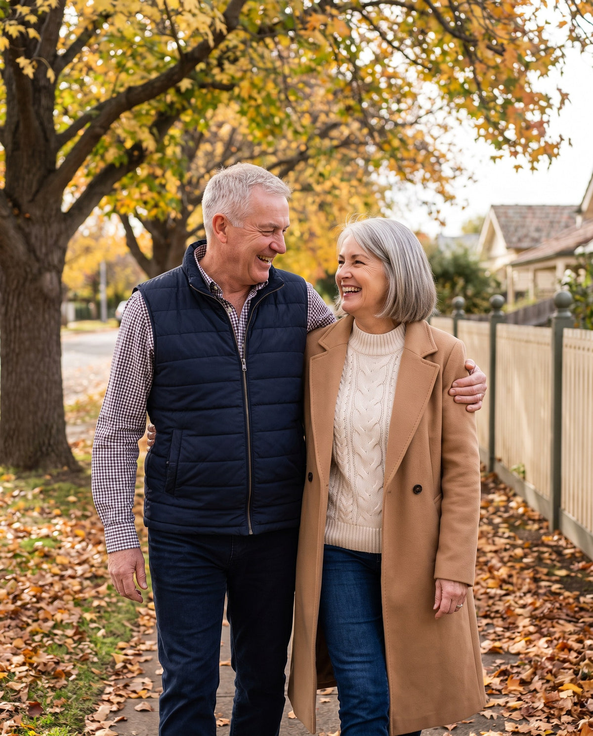 Couple in their sixties laughing on an autumn walk